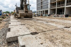 Płyty drogowe RAK-BUD ułożone na placu składowym wśród prefabrykatów betonowych